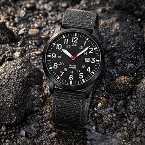May include: Black wristwatch with a black dial, white numerals, and a red second hand. The watch has a black canvas strap and a date window at the 3 o'clock position. The watch is water resistant to 50 meters.