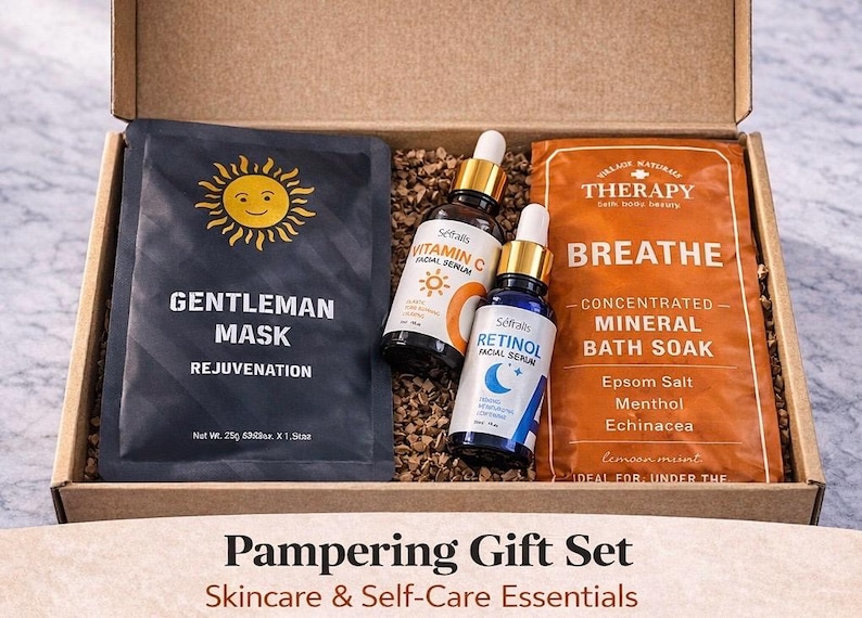 May include: A pampering gift set in a cardboard box. The set includes a black face mask with a sun graphic, two facial serum bottles, and an orange bath soak packet. The box is filled with brown packing material. Text on the box reads "Pampering Gift Set Skincare & Self-Care Essentials."