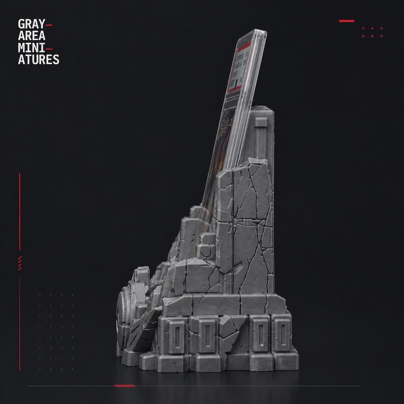 May include: A gray miniature display stand with a weathered, stone-like appearance. The stand is designed to hold a card or other item, with the text "GRAY AREA MINIATURES" visible on the left side. The stand has a detailed, textured surface.