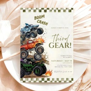 May include: A rectangular invitation card featuring a checkered border and three stacked monster trucks in blue, red, and green. Text reads: BOOM CRASH, OLIVER IS SHIFTING INTO THIRD GEAR!, SATURDAY MAY 14, 2 O'CLOCK PM, 576 OLIVER'S PLACE BROOKLYN NEW YORK.
