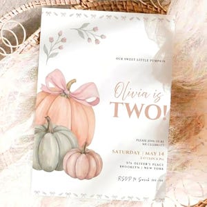 May include: A rectangular birthday invitation card featuring watercolor illustrations of three pumpkins in shades of peach and sage green, with a pink bow on the largest pumpkin. The text reads: Our sweet little pumpkin, Olivia is TWO!, Saturday May 14, 2 o'clock PM, 576 Oliver's Place, Brooklyn, New York, RSVP to Sarah 555-5555.