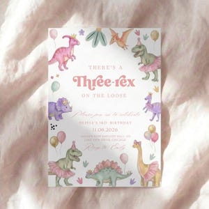 K&ouml;nnte beinhalten: Eine verspielte Einladung zum 3. Geburtstag. Das Design zeigt Aquarellillustrationen von Dinosauriern mit Tutus und Kronen, mit Luftballons und floralen Akzenten. Der Text lautet "There's a Three-rex on the Loose."