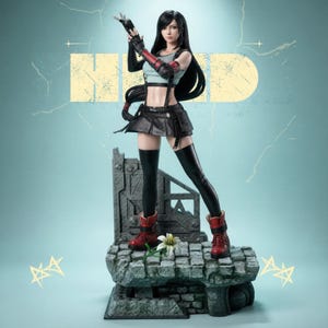 以下が含まれることがあります： 長い黒髪の女性キャラクターの精巧なフィギュア。クロップトップ、スカート、ブーツを着用。フィギュアは、花のある石の台座に立っており、背景はターコイズブルーで「HD」の文字が描かれています。