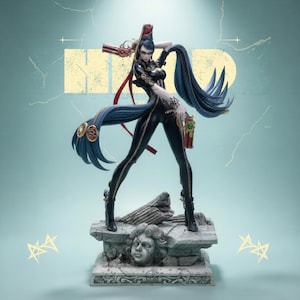 May include: A detailed figurine of a character in a black bodysuit with long blue hair, holding a gun. The figure stands on a stone base with a sculpted face. The background is a light teal color with a yellow rectangle.