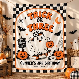 May include: A rectangular wall tapestry featuring a black and white checkered border and a central graphic of a ghost on a skateboard. The text reads TRICK OR THREE, BOO SPOOKY FUN, GUNNER'S 3RD BIRTHDAY, and OCTOBER 15TH, 2026, with orange pumpkins.