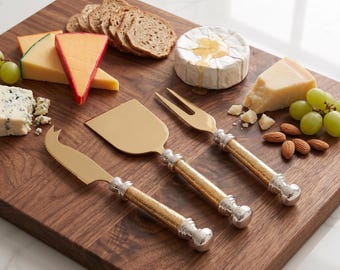 Juego de tres piezas para servir queso con mango de cristal dorado, acero inoxidable tono oro antiguo, tabla para embutidos