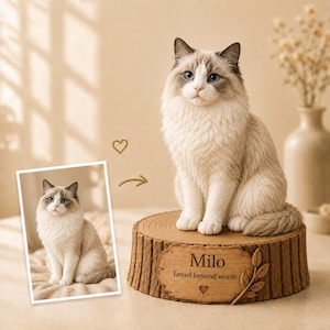 May include: A custom cat figurine featuring a cream and grey long-haired cat with blue eyes sitting on a textured wooden log base. The base includes a plaque engraved with the name Milo, the text Loved beyond words, and a small heart icon.