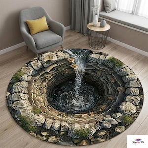 May include: A round rug with a 3D rendering of a well with water cascading into it. The rug features a stone wall design around the well's opening, with green patches of grass. The rug is on a wooden floor.