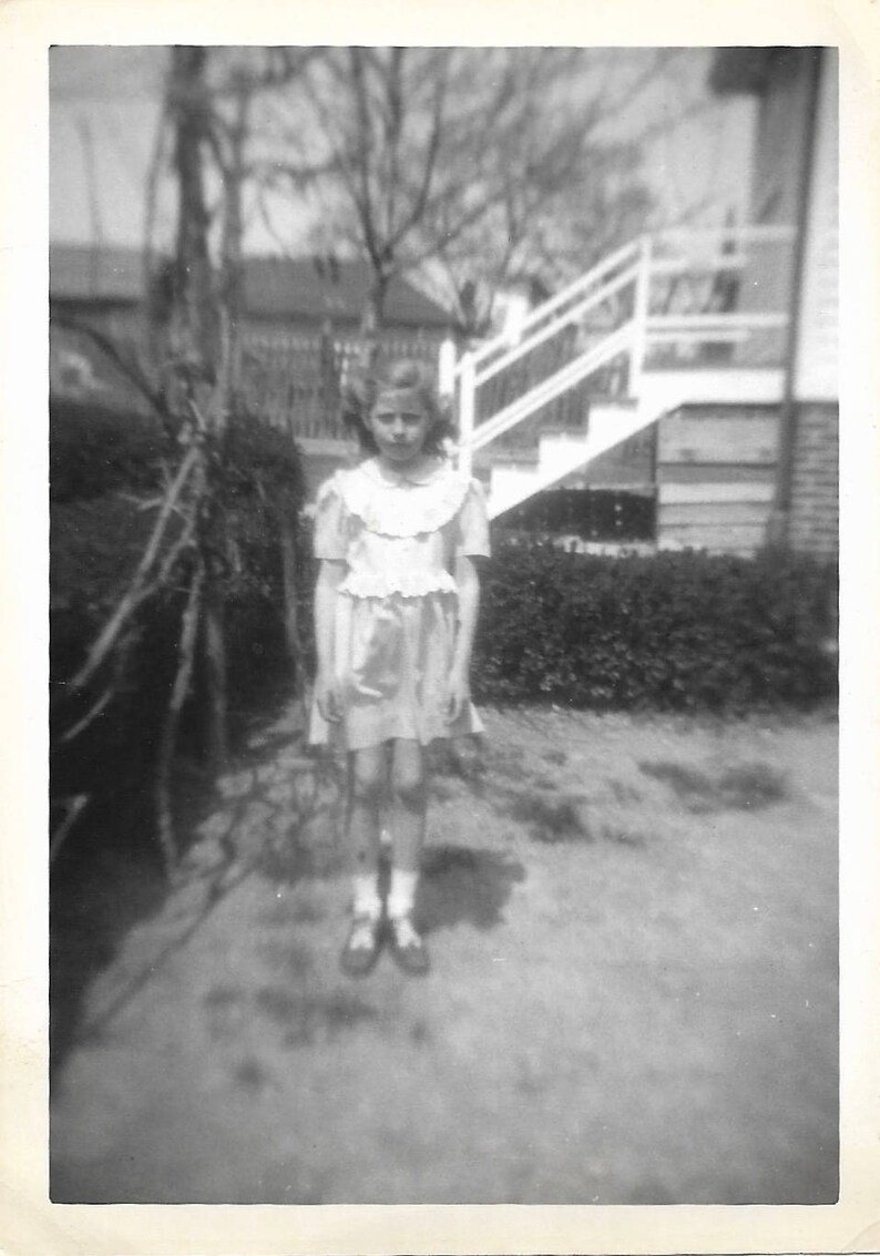 Peculiar child stiff pose unusual black white snapshot photo