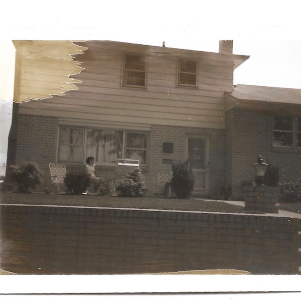 Suburbia Vintage Polaroid Photo 1960’s Black & White Instant Photography Woman Sitting In Lawn Chair In Front Of Two-Story House Abstract