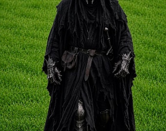 May include: A dark, hooded figure wearing a jagged, metallic crown-like helmet and a tattered black cloak. The costume includes intricate metal gauntlets, a leather belt with a small pouch, a sword hilt, and metallic greaves covering the lower legs.
