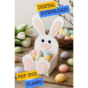 May include: A white wooden Easter bunny-shaped basket with pink details, filled with speckled pastel eggs. The image includes the text "DIGITAL DOWNLOAD!" and "PDF SVG PLANS!" on yellow and blue banners. The basket is on a wooden surface.
