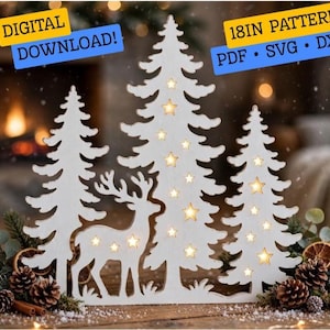 May include: A white laser-cut wooden decoration featuring three pine trees and a deer silhouette with star-shaped cutouts. Text reads: DIGITAL DOWNLOAD! 18IN PATTERN PDF SVG DXF. The design is illuminated from behind, creating a warm glow.