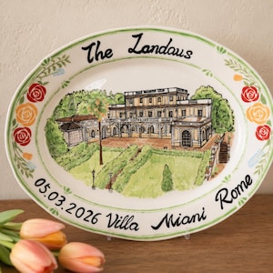 Op de afbeelding: Een ovale keramische schaal met een handgeschilderde illustratie van een villa met meerdere verdiepingen, boogramen en een tuin. De tekst luidt The Landaus, 05.03.2026 en Villa Miani Rome. De rand is versierd met rode en oranje bloemmotieven.