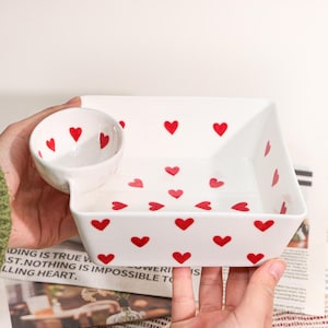 May include: A set of three ceramic mugs with a speckled, matte finish in cream, light grey, and dark grey. Each mug has a simple, minimalist design and a rounded handle.