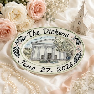 Pode incluir: Um prato oval de cerâmica com uma ilustração pintada à mão de um edifício clássico com colunas. O texto "The Dickens" está escrito no topo e "June 27, 2026" na base em letra preta, emoldurado por motivos de folhas verdes.