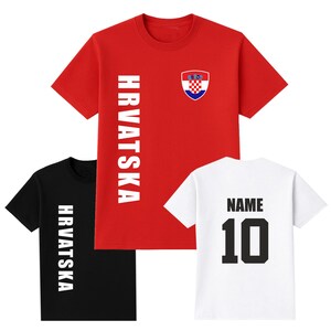 May include: Three short-sleeved t-shirts. A red shirt with the word "HRVATSKA" in white and a Croatian coat of arms. A black shirt with the word "HRVATSKA" in white. A white shirt with the word "NAME" and the number "10" in black.