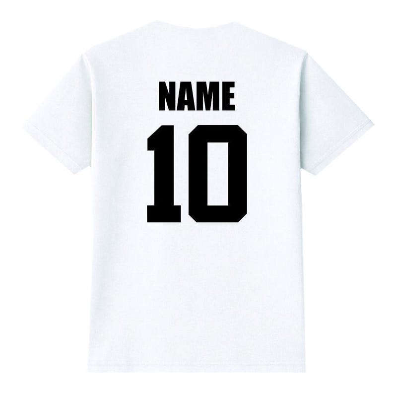 May include: White t-shirt with the word "NAME" printed in black above the number "10" in black. The shirt is a classic crew neck style.