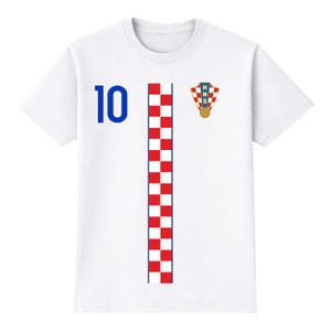 Pu&ograve; includere: Maglietta bianca con un design da maglia da calcio croata. Presenta il numero 10 blu a sinistra, una striscia a scacchi rossi e bianchi al centro e l'emblema croato a destra.