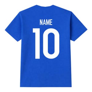 Pu&ograve; includere: Una maglietta blu reale con la scritta "NAME" in bianco sopra il numero "10". Il numero &egrave; grande e centrato sul retro della maglietta. La maglietta ha maniche corte e scollo tondo.