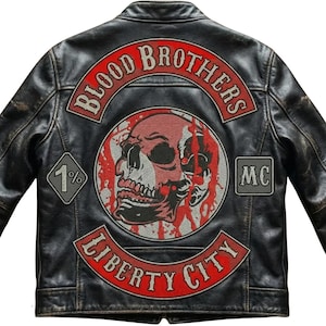 Op de afbeelding: Een zwart leren jack met een grote rugpatch met een schedelafbeelding, rode bloedspatten en de tekst Blood Brothers, 1%, MC en Liberty City. Het jack heeft een verweerde afwerking, een klassieke kraag en lange mouwen.