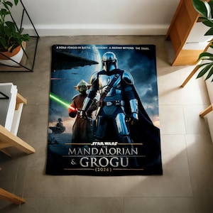 Pode incluir: Uma manta retangular com tema Star Wars com The Mandalorian e Grogu. A manta tem um fundo azul escuro com o texto "A BOND FORGED IN BATTLE. A DESTINY BEYOND THE STARS." A manta tamb&eacute;m tem o texto "STAR WARS THE MANDALORIAN & GROGU (2026)".