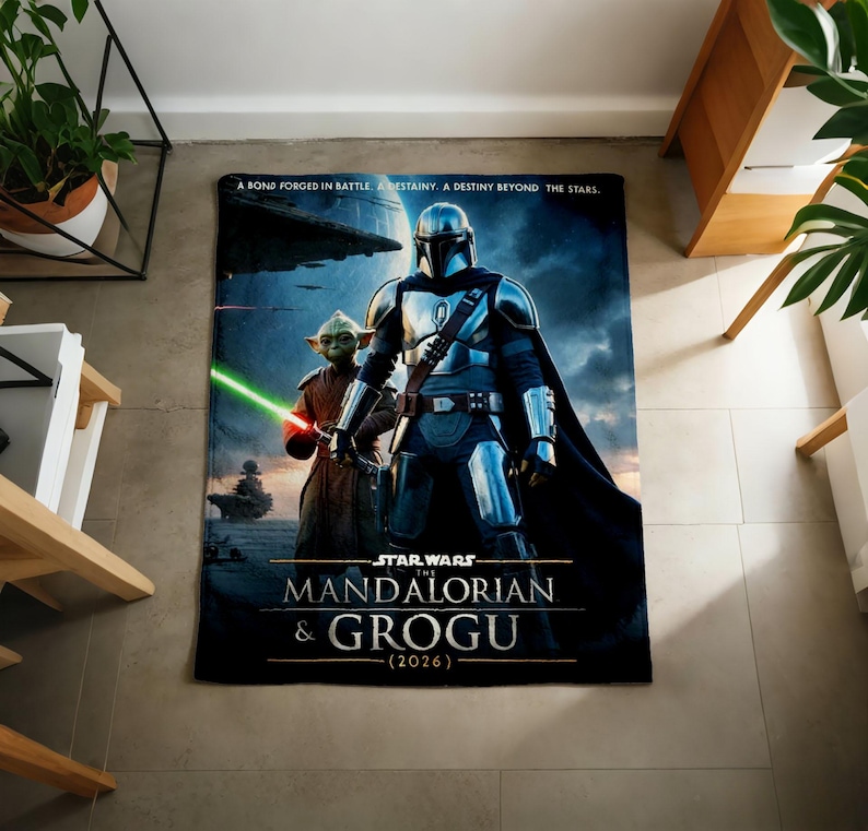 Pode incluir: Uma manta retangular com tema Star Wars com The Mandalorian e Grogu. A manta tem um fundo azul escuro com o texto "A BOND FORGED IN BATTLE. A DESTINY BEYOND THE STARS." A manta tamb&eacute;m tem o texto "STAR WARS THE MANDALORIAN & GROGU (2026)".