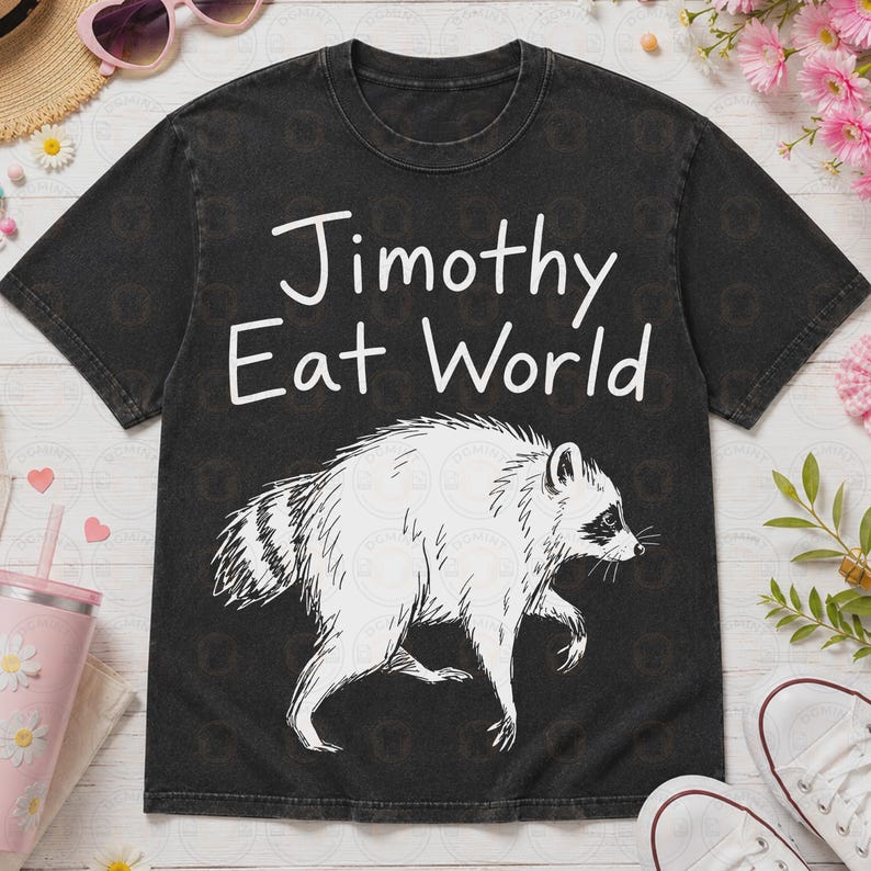 May include: A black short-sleeve t-shirt with a white graphic of a raccoon and the text "Jimothy Eat World" printed in white. The shirt features a crew neckline and a washed-out, vintage-style fabric texture throughout the garment.