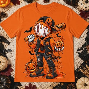 Może przedstawiać: Pomarańczowy t-shirt z grafiką postaci z głową w kształcie piłki baseballowej, ubranej w czapkę, bluzę z kapturem i kurtkę, trzymającej kij baseballowy oraz małą dynię. Postać otoczona jest nietoperzami i pomarańczowymi kroplami na tle.