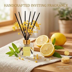 Puede incluir: Un difusor de varillas de vidrio transparente con tapa dorada, que contiene flores secas amarillas y varillas negras. La etiqueta dice HANDCRAFTED INVITING FRAGRANCE y LEMON VERBENA. Dos mitades de limón, hojas verdes y una esponja pequeña. 100ml.