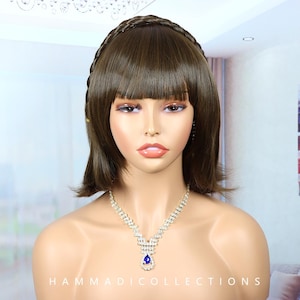May include: A brown wig with a braided headband and blunt bangs. The mannequin is wearing a sparkling silver necklace with a blue teardrop-shaped pendant. The text "HAMMADICOLLECTIONS" is visible at the bottom.