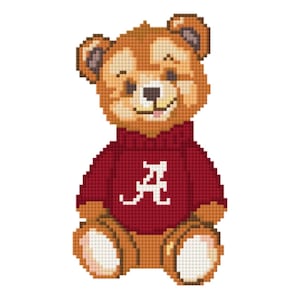 May include: A cross-stitch design of a teddy bear wearing a crimson sweater with a white "A" on the front. The bear has brown fur, a smiling face, and is sitting upright. The background is white.