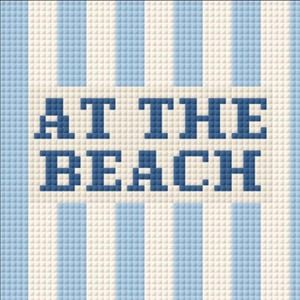 May include: A pixelated design with alternating vertical stripes of light blue and white. The words "AT THE BEACH" are displayed in dark blue pixelated letters, centered on the image. The overall theme suggests a beach or summer motif.