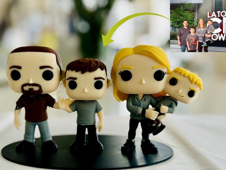 May include: A set of four custom vinyl figures representing a family, including two adults and two children. The figures feature large heads, black circular eyes, and are mounted on a black circular base, modelled after a photograph of a family.