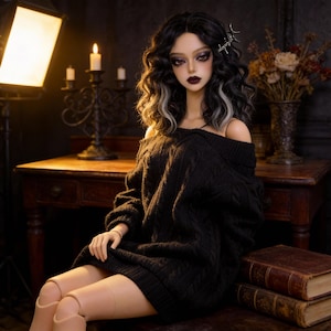May include: A doll with black wavy hair with gray highlights, wearing a black off-the-shoulder sweater. The doll has dark makeup and is sitting on a wooden table. A candle holder and books are in the background.