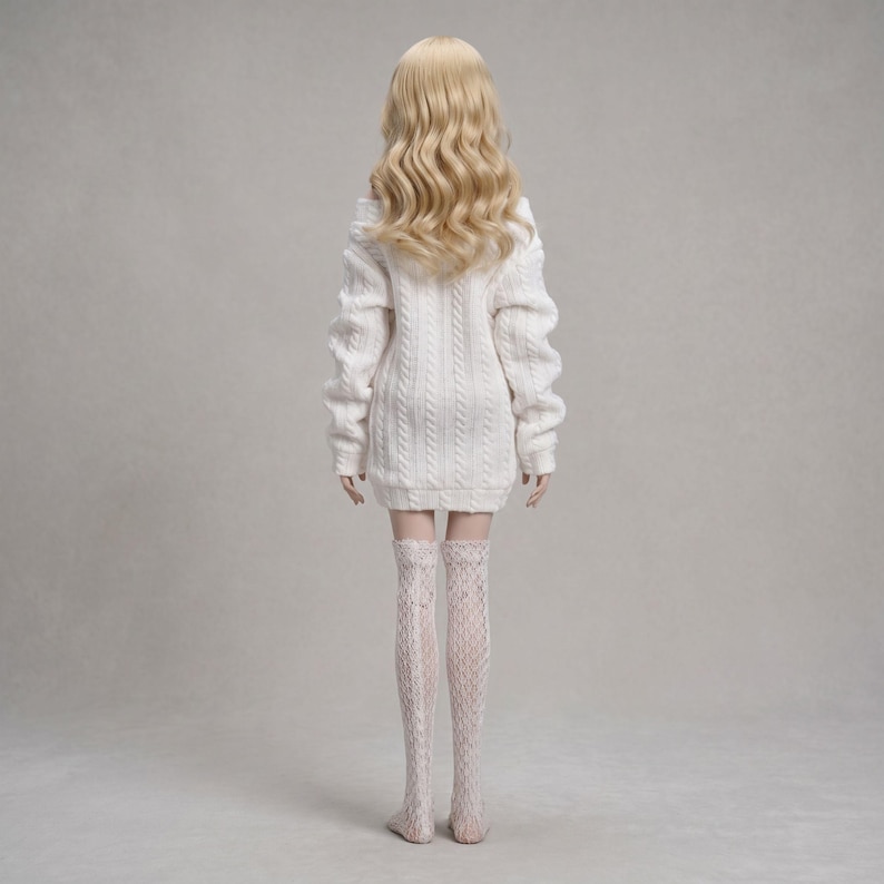 Puede incluir: Una mu&ntilde;eca con cabello rubio largo y ondulado que viste un vestido tipo su&eacute;ter blanco de punto trenzado y medias blancas estampadas hasta el muslo. La mu&ntilde;eca se ve desde atr&aacute;s, mostrando el patr&oacute;n de punto del su&eacute;ter y el dise&ntilde;o de encaje de las medias.