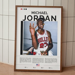 以下が含まれることがあります： シカゴ・ブルズのジャージを着たマイケル・ジョーダンが3本の指を立てている額入りのポスター。ポスターには「MICHAEL JORDAN」という名前が大きく書かれており、経歴や統計情報も記載されています。フレームは温かみのある茶色です。