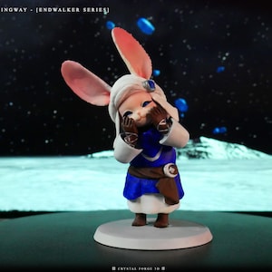 May include: A figurine of a character with large pink rabbit ears, wearing a white hat, blue and white outfit, and brown belt. The character is covering its face with its hands. The base is white, and the background is a space scene. Text on the top left reads "BLUSHINGWAY - [ENDWALKER SERIES]"