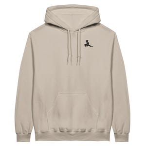 Puede incluir: Sudadera con capucha beige con capucha con cordón y bolsillo de canguro. Una pequeña figura negra bordada está en la parte superior izquierda del pecho. La sudadera con capucha está hecha de un material suave y cómodo.