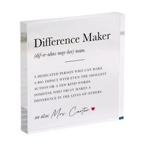 May include: A clear acrylic block with the words "Difference Maker" in black, along with a definition. The text includes "Mrs. Carter" and a red heart. A thoughtful gift.