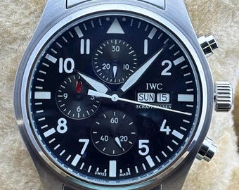 Reloj de pulsera IWC Pilot's Chrono automático vintage con esfera negra, caja y brazalete de acero inoxidable, fondo transparente y función de fecha/día para hombre.