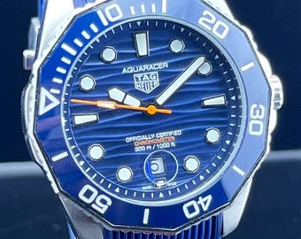 Reloj de hombre Tag Heuer Aqua-Racer automático vintage con esfera azul, caja plateada, correa de caucho azul, bisel giratorio y fecha funcional, de acero inoxidable.