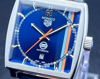 Reloj de pulsera para hombre Tag Heuer Monaco Gulf Edition automático vintage con esfera azul, caja plateada, correa de cuero azul, fecha funcional y caja de acero inoxidable.