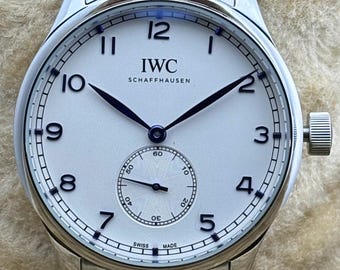 Reloj de pulsera IWC PORTUGIESER vintage automático para hombre, esfera blanca, caja y brazalete de acero inoxidable, segundero pequeño en funcionamiento, fondo transparente.