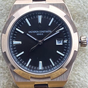 Relógio de pulso masculino vintage Vacheron Constantin Geneve automático com mostrador marrom, pulseira de borracha marrom, caixa em ouro rosa, fundo transparente e função de data.