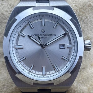 Relógio de pulso masculino vintage Vacheron Constantin Geneve automático, mostrador prateado, pulseira de couro preta, caixa prateada, fundo transparente, com data funcionando.