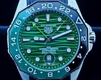 Reloj de hombre Tag Heuer Aqua-Racer automático vintage con esfera verde, caja plateada, correa de caucho negra, bisel giratorio y fecha funcional, de acero inoxidable.