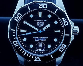 Reloj de hombre Tag Heuer Aqua-Racer automático vintage con esfera negra, caja plateada, correa de caucho negra, bisel giratorio y fecha funcional, de acero inoxidable.