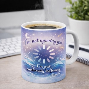 May include: White ceramic mug with a celestial design and the text "I'm not ignoring you, I'm just emotionally buffering -Pisces." The mug features a starry sky, waves, and a loading symbol.