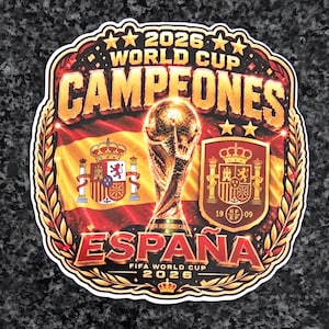 Op de afbeelding: Een decoratieve sticker met de tekst 2026 WORLD CUP CAMPEONES ESPANA. Het ontwerp bevat een gouden FIFA Wereldbeker-trofee, de Spaanse nationale vlag, het Spaanse wapenschild en een schild met het RFEF-logo, alles omlijst door gouden lauweren.